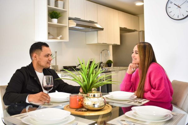 Un hombre y una mujer sentados en la mesa de una cocina.